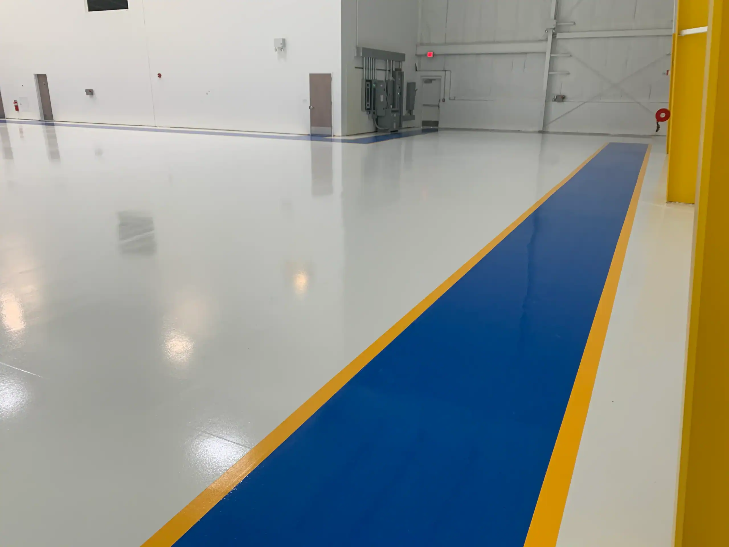Spacious white industrial room with epoxy floors installed by a top contractor in Bohemia, NY.