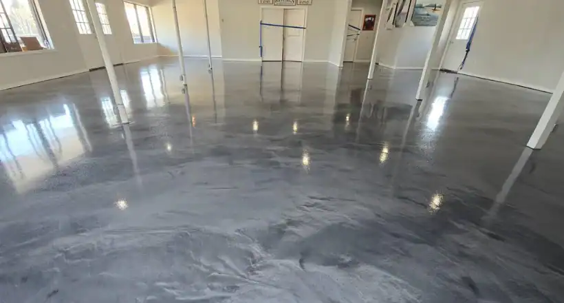 Spacious NY room with shiny gray epoxy floor by Epoxy Flooring Contractor Bohemia, white walls, windows.