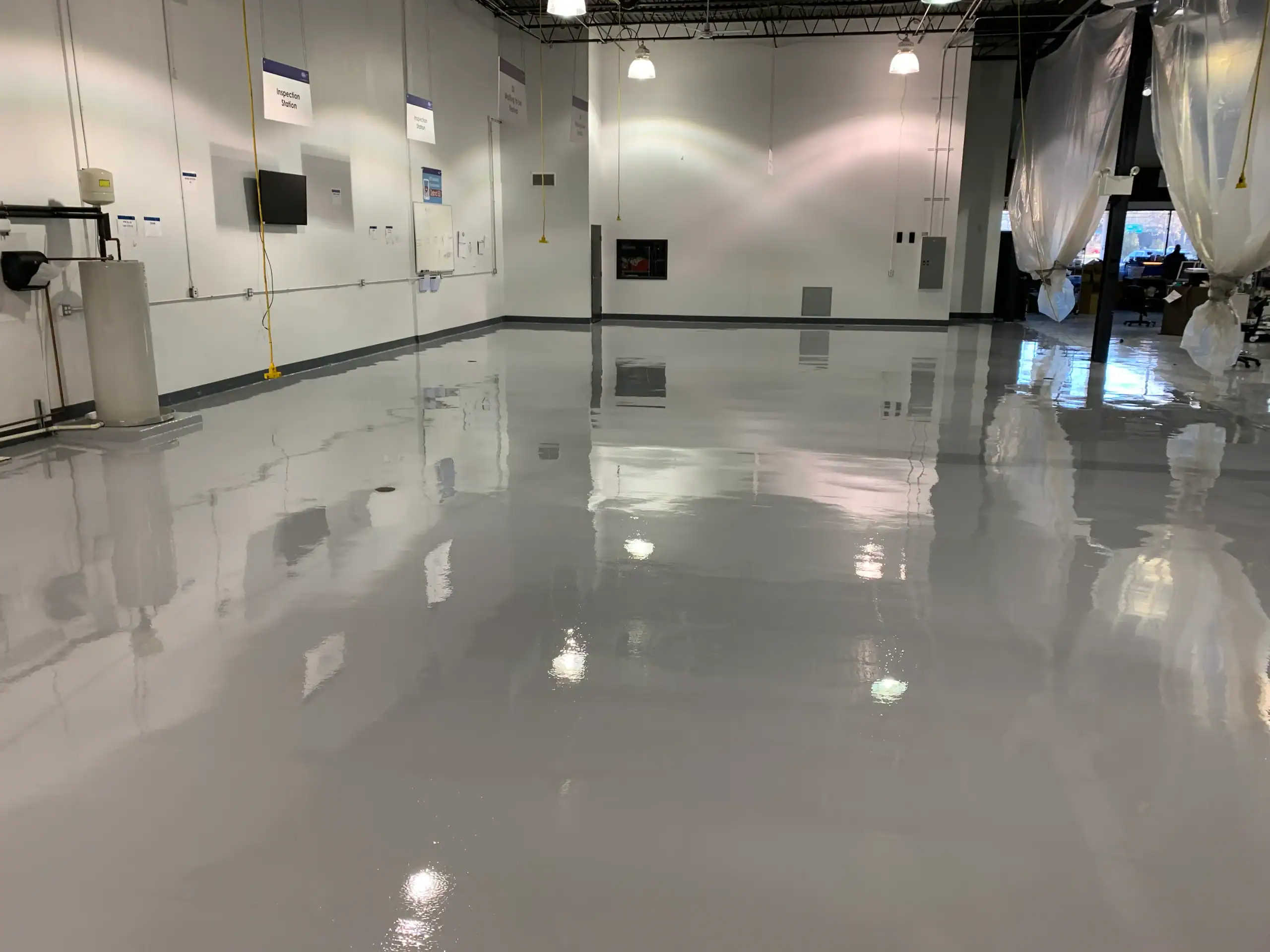 Spacious, empty room in NY featuring a shiny grey epoxy floor by Epoxy Flooring Contractor Bohemia.