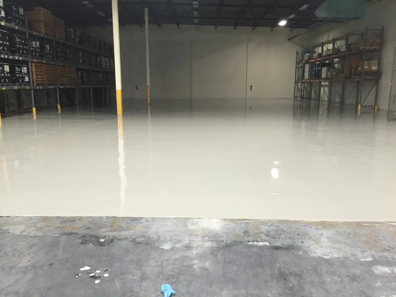 An empty warehouse with shiny epoxy floors installed by an Epoxy Flooring Contractor in Bohemia, NY.