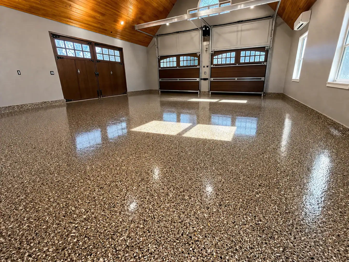 A spacious, clean NY garage with a shiny epoxy floor installed by Epoxy Flooring Contractor Bohemia.